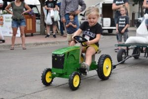 Photo of little boy riding toy tractor
